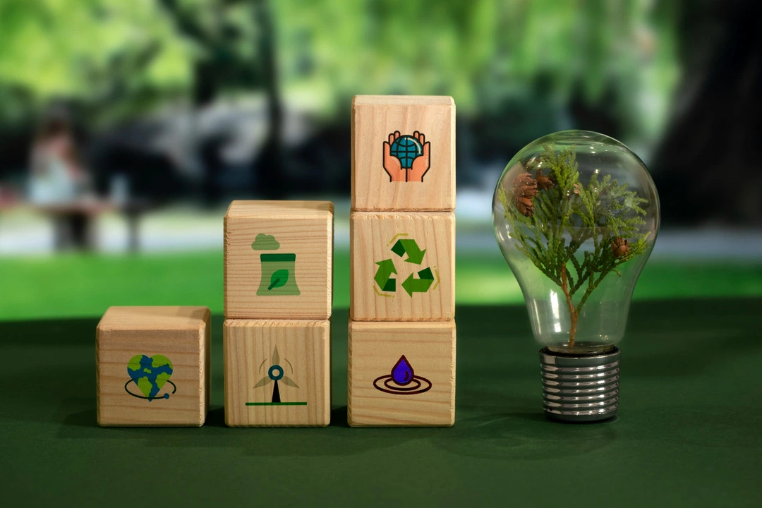 Sustainability symbols and a plant in a light bulb emphasize green innovation for businesses