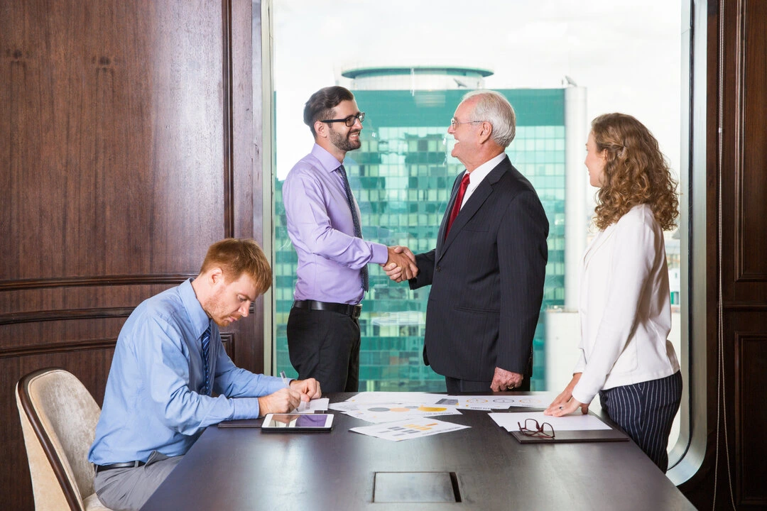 Professionals shaking hands during a business meeting to establish a new partnership.