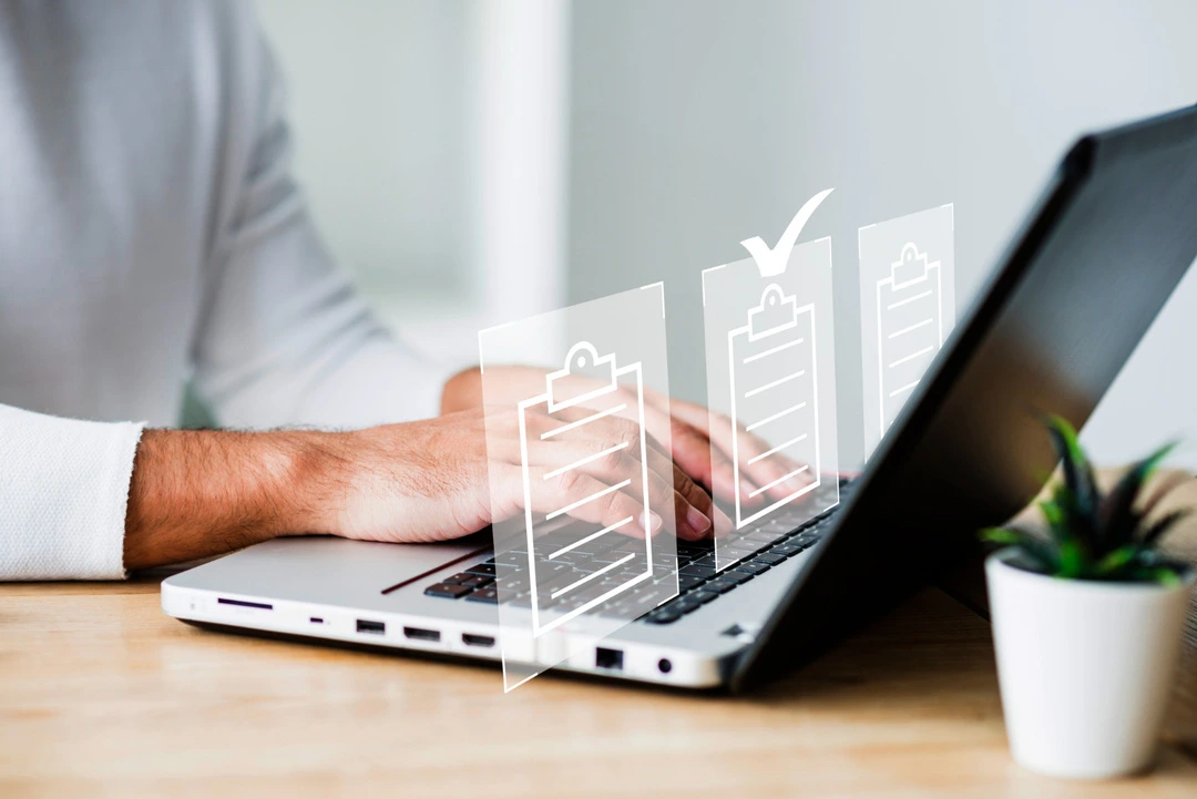 A person types on a laptop, representing efficient digital record organization.
