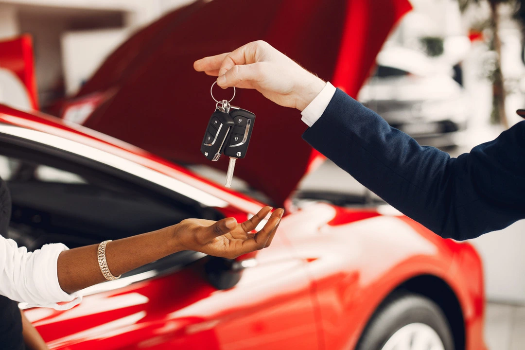 Key exchange during a car rental transaction, highlighting rental business services.