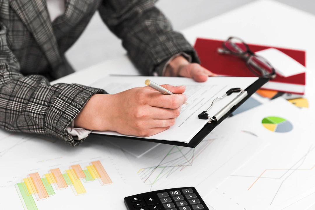 Individual reviewing documents and charts, crucial for creating a car rental business plan.