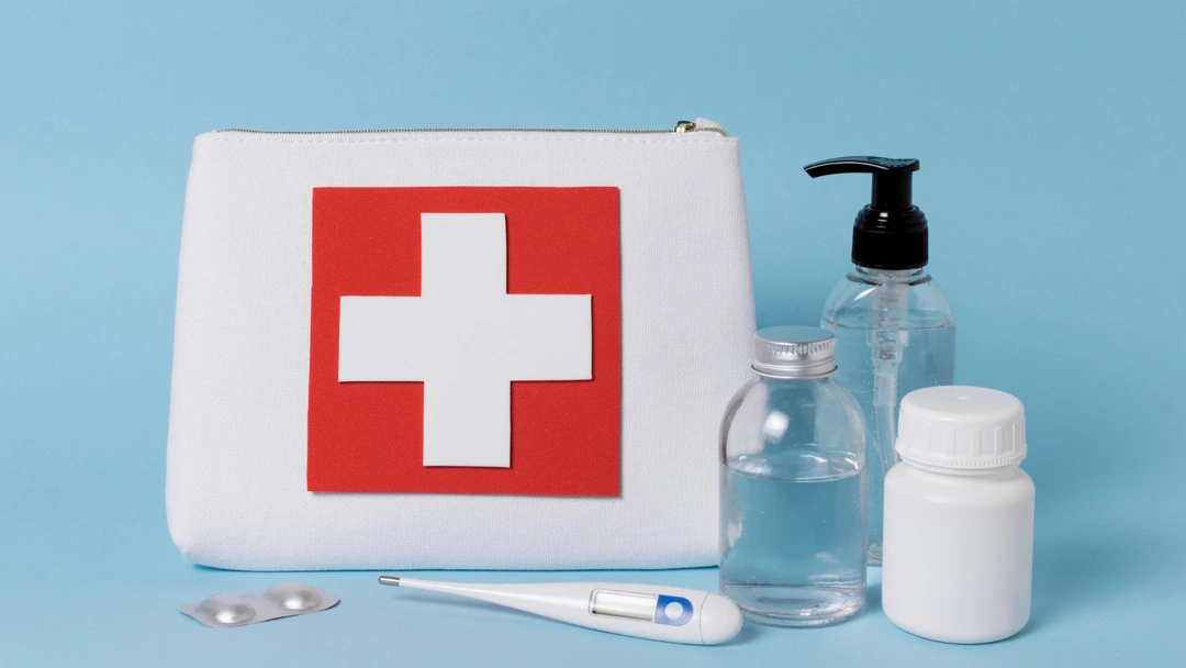 First aid kit with medical supplies, including bottles, pills, and a thermometer, for emergencies.