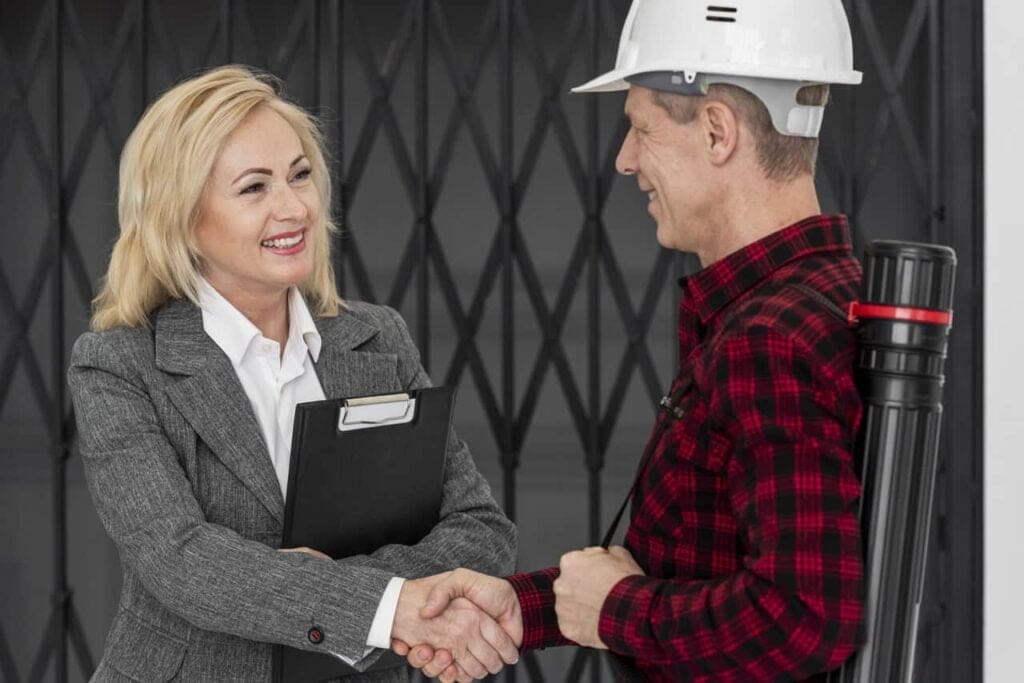 Handshake between a business professional and a construction worker, illustrating the positive impact of asset tracking on equipment rental services