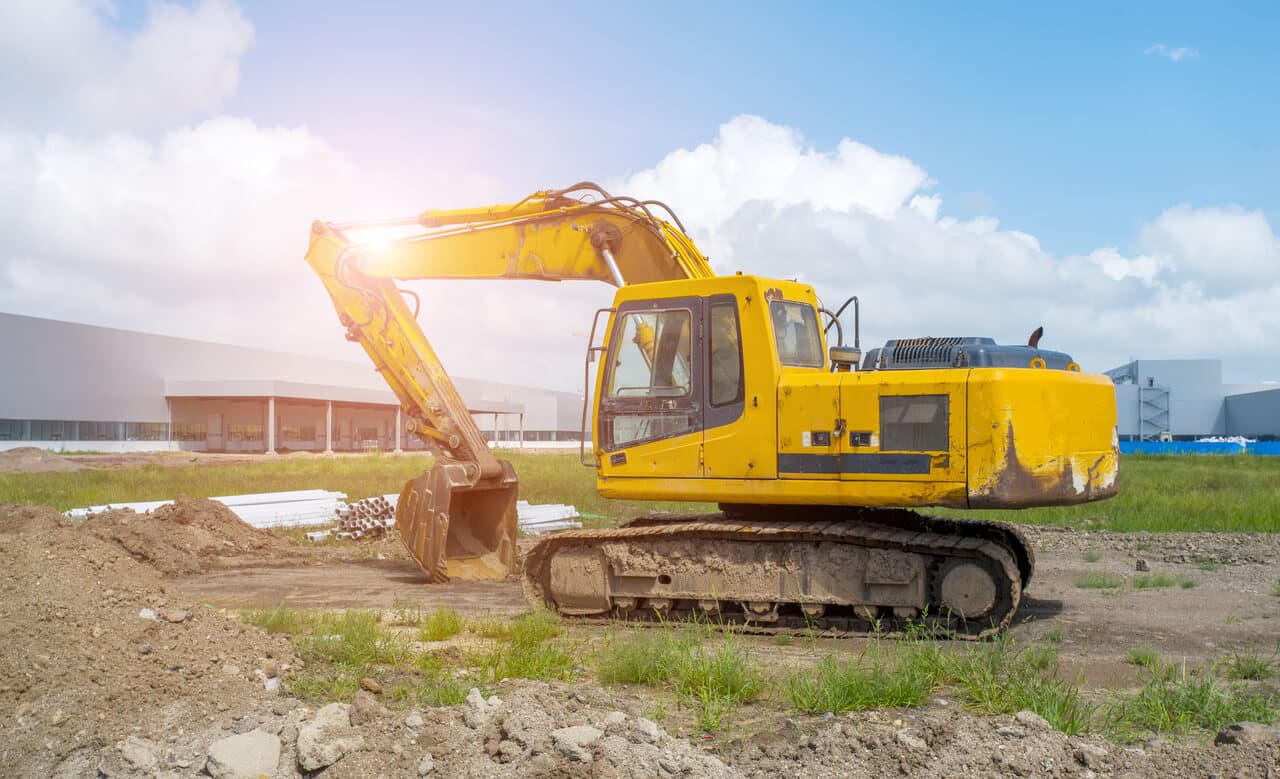 Construction site with a yellow excavator highlighting asset tracking benefits for equipment rentals