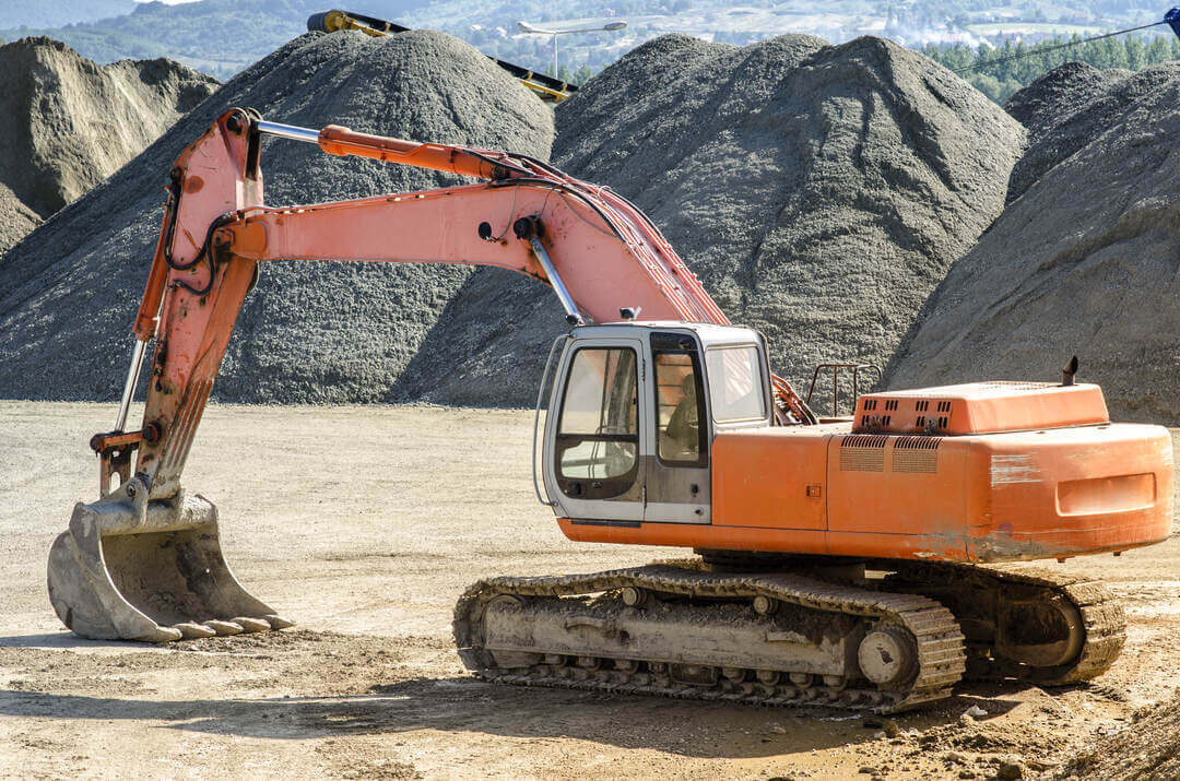 Orange excavator on gravel, used for "How Much Does an Excavator Cost?" guide
