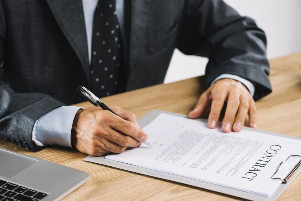 A person signing a legal document for business registration.