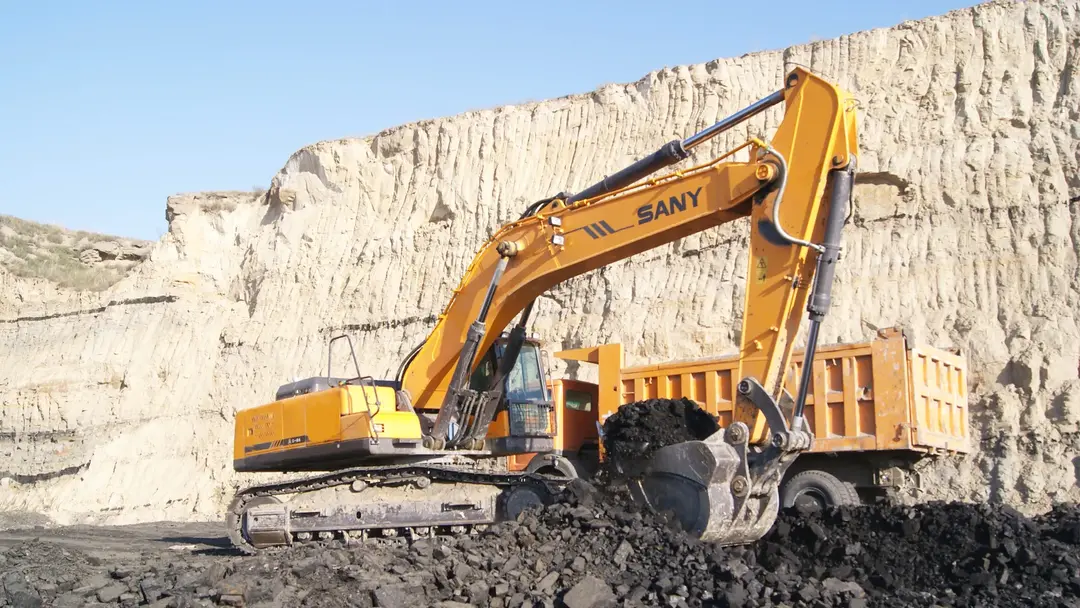 Sany tracked excavator operating in a quarry with dirt pile