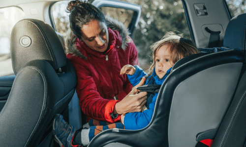 A Mom is adjusting her baby's car seat