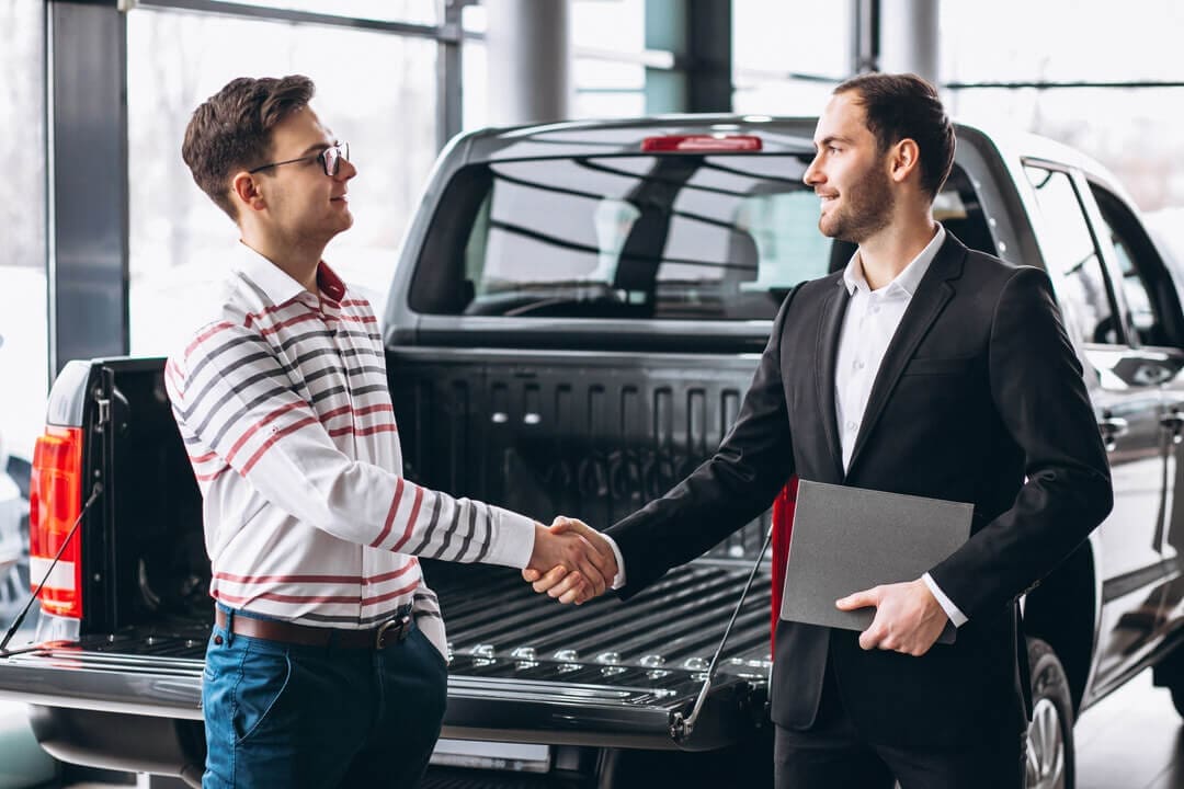 Agreement on vehicle rental business with a black pickup truck in the background