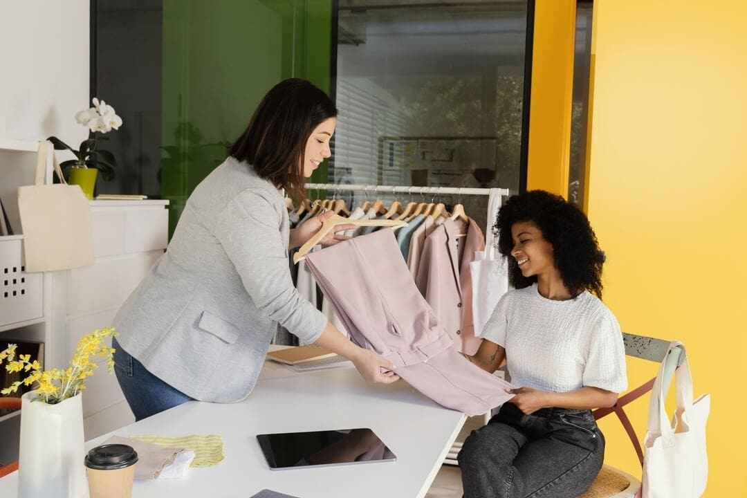 Fashionable duo exploring clothing rental ideas in a modern studio