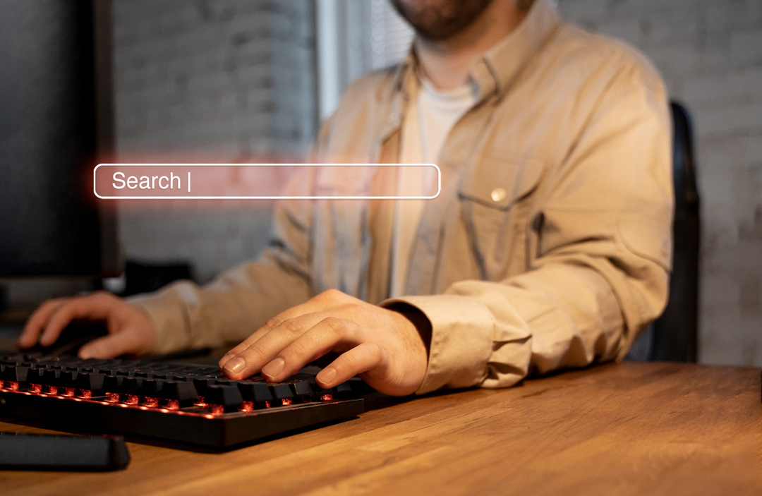 Hands typing with search bar, symbolizing strategies for online visibility.