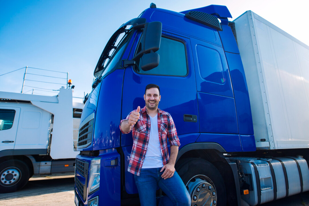 Proud entrepreneur posing with a blue trailer truck, symbolizing a trailer rental business startup.