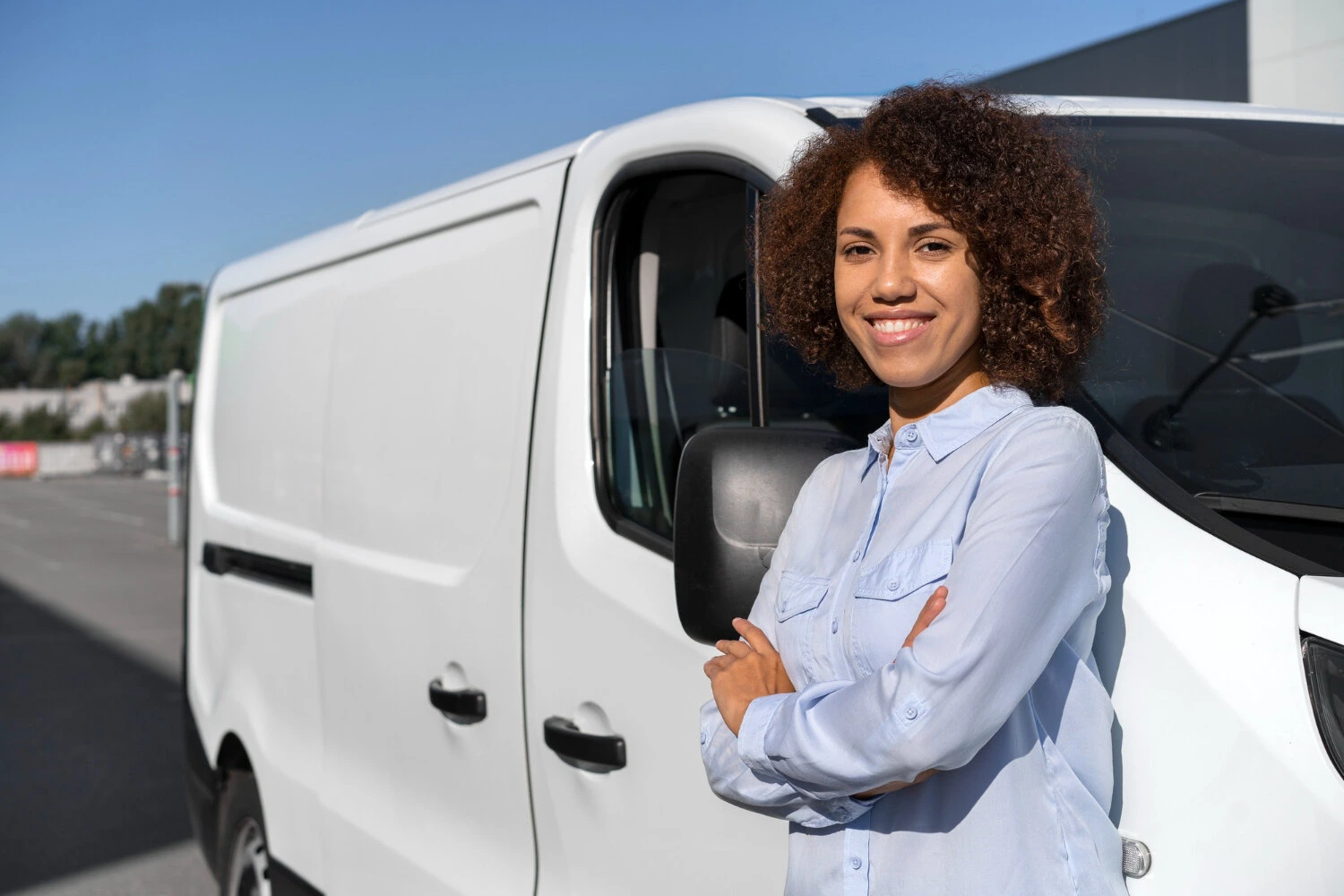 A Confident person standing by a white van, showcasing rental business expertise.