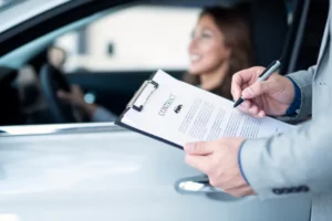 Car insurance paperwork with vehicle in the background