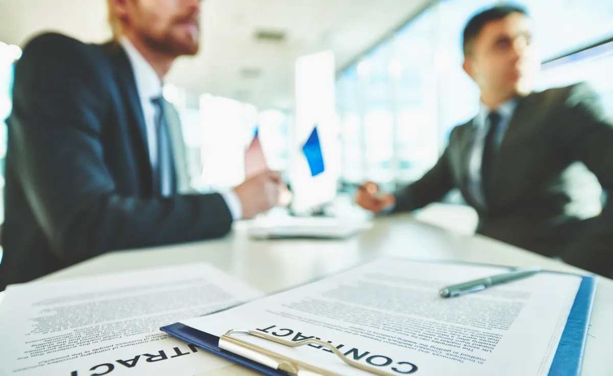Businessmen reviewing legal contracts to plan finances for a venue rental business