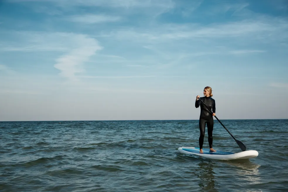 A Person stand-up paddleboarding in a calm ocean