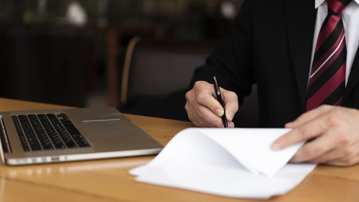 Man in a suit signing legal documents for a baby rental business