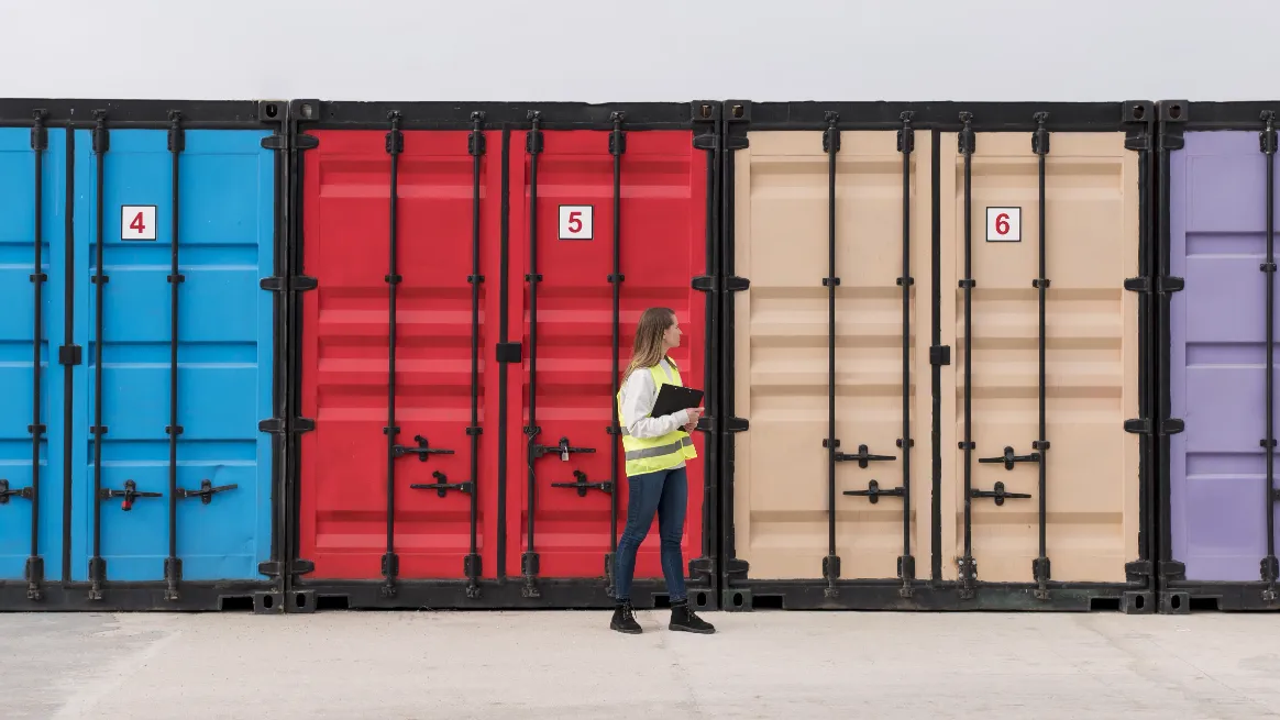 Inspector in safety vest reviewing rental containers in shipping yard
