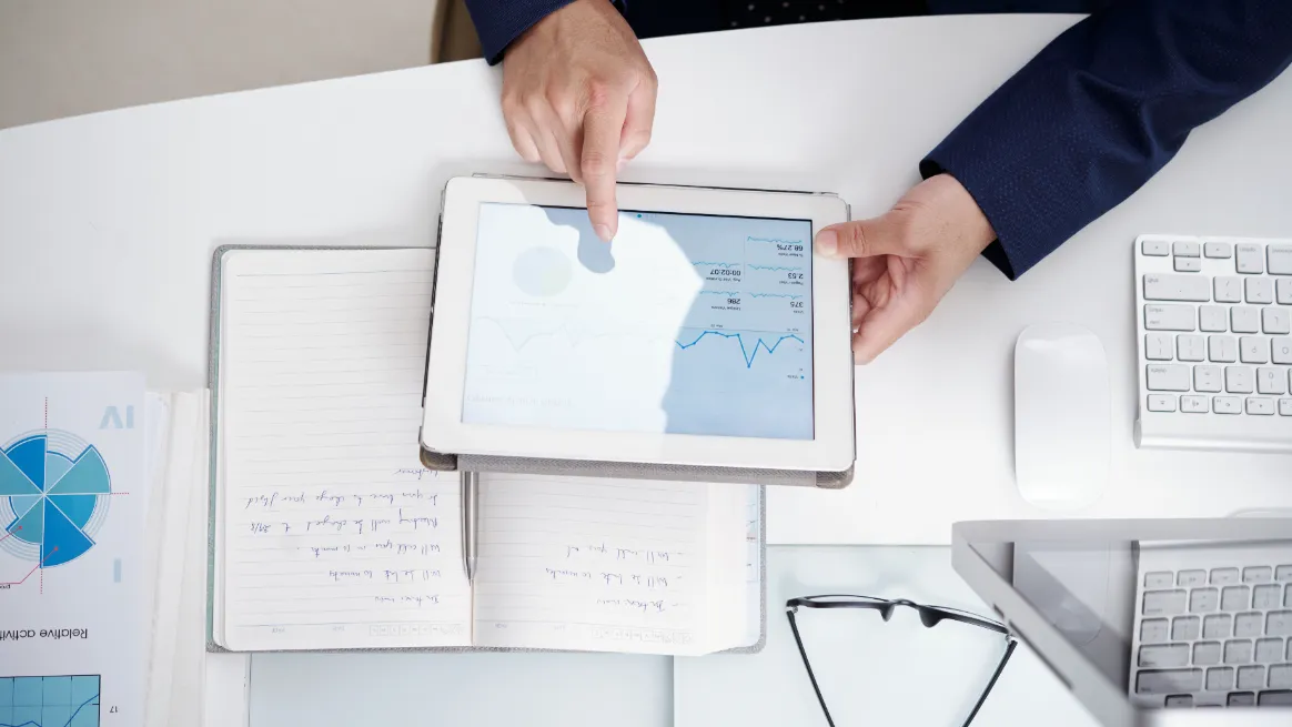 Business owner analyzing financial data with digital and handwritten tools