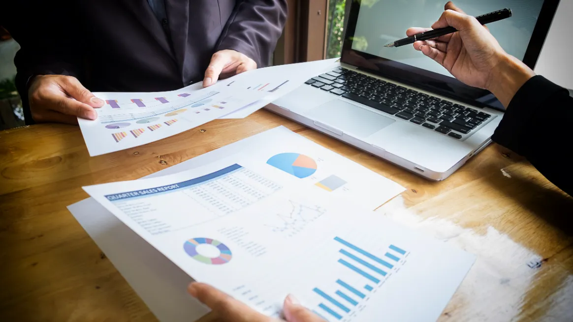 Two people analyzing the tent rental market data at a desk