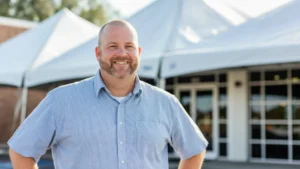 Tent rental business owner posing confidently near the event tent