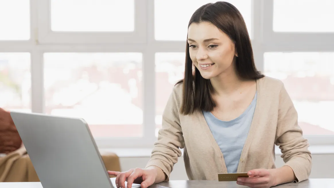 Person making an online payment with a credit card and a laptop